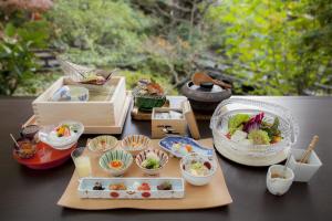una mesa cubierta con tazones de comida en una mesa en Jinya Ryokan, en Hadano