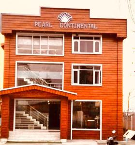a red brick building with apedral centennial sign on it at hotel pearl continental in Srinagar