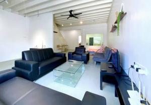 a living room with blue furniture and a ceiling fan at Modern Cozy House 4 ROOM 10pax@Bukit Mertajam in Bukit Mertajam