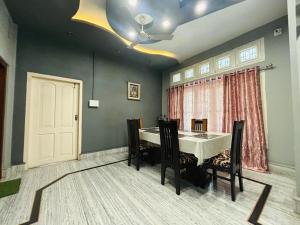 a dining room with a table and chairs and a door at N N residency in Sibsāgar