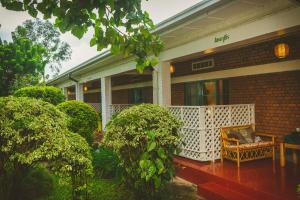 a porch of a house with a bench on it at Isange Paradise Resort in Ruhengeri