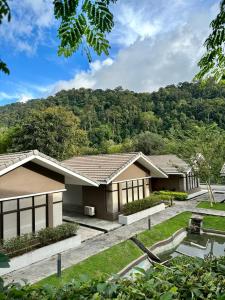 a house with a mountain in the background at Rebungan Resort Langkawi in Kuah