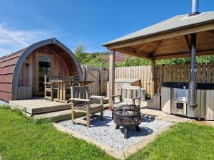 a backyard with a gazebo and benches and a grill at Hillside Havens in Dufftown