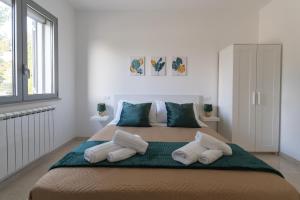 ein Schlafzimmer mit einem großen Bett mit vier Kissen in der Unterkunft Smilax - Hydruntum Holiday Rooms in Otranto