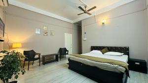 a bedroom with a bed with a ceiling fan at N N residency in Sibsāgar