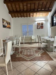 una sala da pranzo con tavoli e sedie bianchi di Villa Roberta B&B a Ferrara