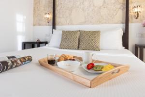 カリアリにあるLa Residenza Sul Largoのベッドの上にフルーツと野菜のトレイ