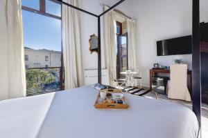 Un dormitorio con una cama con una bandeja encima. en La Residenza Sul Largo, en Cagliari