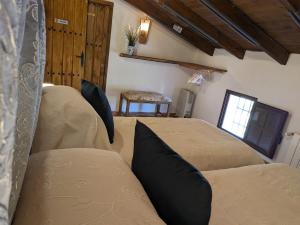a bedroom with two beds and a couch and a window at Casa KiSi Cottage, Rural Boutique Bed & Breakfast in Málaga
