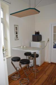 eine Küche mit einer Theke mit vier Stühlen in der Unterkunft Ferienwohnung Bernhard in Zinnowitz