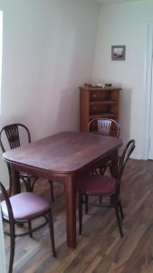 uma mesa de madeira com cadeiras e uma cómoda num quarto em Ferienwohnung Julia em Zinnowitz