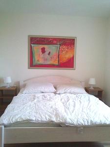 um quarto com uma cama com um quadro por cima em Ferienwohnung Julia em Zinnowitz