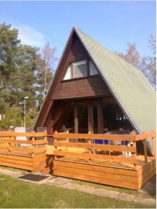 ein Haus mit einem Strohdach und einem Holzzaun in der Unterkunft Ferienhaus Finnhütte in Zinnowitz