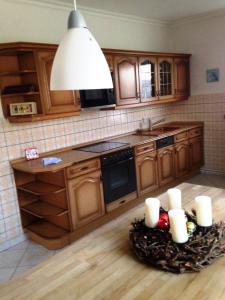a kitchen with wooden cabinets and a table with candles at Ferienwohnung Lara in Zinnowitz
