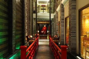 a man in a red coat walking down a hallway at Shanghai Mansion Bangkok in Bangkok