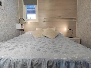 a large bed with two pillows on top of it at Mummon Mökki in Lokka