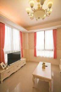 a living room with a flat screen tv and red curtains at 城市角落民宿 in Hualien City