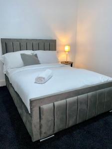1 dormitorio con 1 cama grande con sábanas blancas en Home In Medway, en Chatham