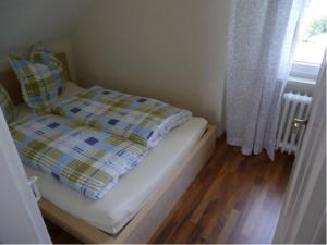 een kleine slaapkamer met een bed en een raam bij Ferienwohnung Ida in Ahlbeck