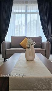 a living room with a couch and a vase on a table at Lodge 16 Private Villa in Kuah