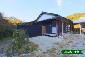 a small blue house with a porch and a yard at まんのう清流庵 in Manno