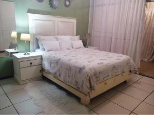 Modern style Apartment in Pretoria-Central في بريتوريا: غرفة نوم بسرير كبير مع لحاف أبيض