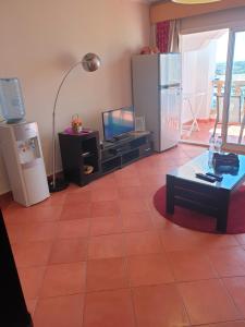 uma sala de estar com piso em azulejo e uma televisão em شقة فندقية بورتو مارينا الساحل الشمالي em El Alamein