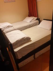2 camas en una habitación con sábanas blancas en شقة فندقية بورتو مارينا الساحل الشمالي en El Alamein