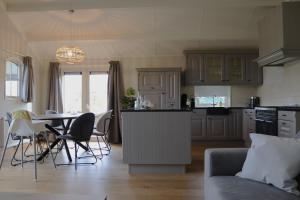 uma cozinha e sala de estar com mesa e cadeiras em Hoeve de Zeeanjelier em Sint-Annaland