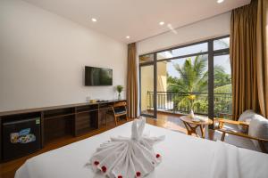 a hotel room with a bed and a large window at Flower Villa in Hoi An