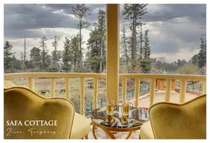 einen Balkon mit einem Tisch und Stühlen sowie einem Fenster in der Unterkunft Snow Resort Gulmarg in Gulmarg