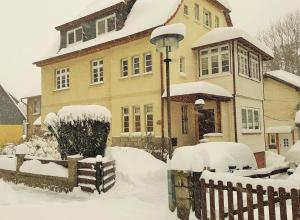 ヴェルニゲローデにあるFerienwohnung-Himmelpforteの柵の前の雪に覆われた家