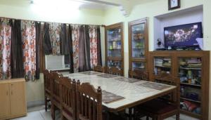 斋浦尔BOBY HOME STAY "BOBY MANSION" Jaipur的一间带桌椅和电视的餐厅