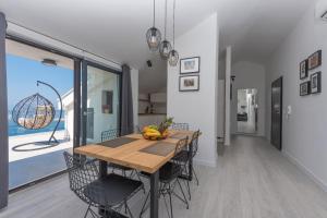 a dining room with a wooden table and chairs at Sun Paradise Apartment in Podgora