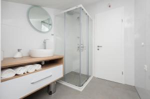 a bathroom with a glass shower and a sink at Sun Paradise Apartment in Podgora +23 photos