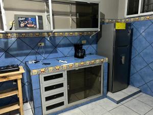 a kitchen with a blue counter and a refrigerator at Casco histórico Atenea in Comayagua