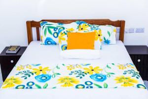 un letto con un copriletto floreale sopra di Double A Unique Homes a Mombasa