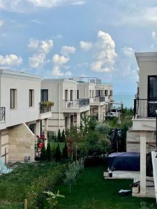 een rij witte appartementsgebouwen met een tuin bij Our dreamy holiday home by the sea in Pomorie