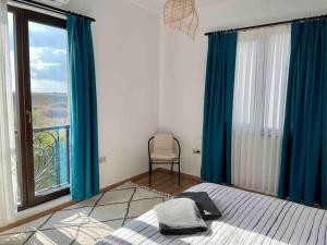 1 dormitorio con cortinas azules, 1 cama y ventana en Our dreamy holiday home by the sea, en Pomorie