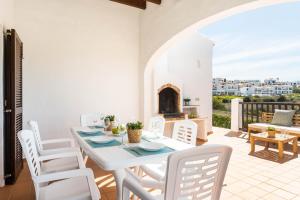 a dining room with a table and chairs and a fireplace at Villas Playas de Fornells in Fornells