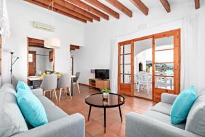a living room with a couch and a table at Villas Playas de Fornells in Fornells