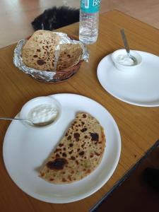 une assiette blanche avec un morceau de pain sur une table dans l'établissement Kedar Valley Resorts Kedarnath, à Phata