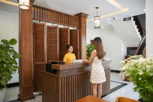 a woman standing at a cash register in a room at Flower Villa in Hoi An