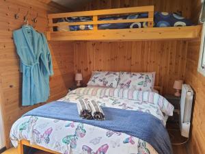 a bedroom with a bed in a wooden room at Luxury Railway carriage with own private hot tub in Clodock