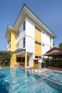 a building with a swimming pool in front of a building at Flower Villa in Hoi An