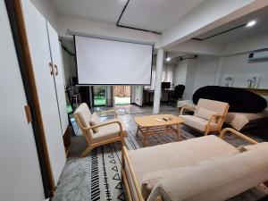 Bali-style studio apartment في Ban Madua Wan: غرفة معيشة فيها شاشة كبيرة في الوسط