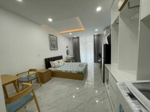uma sala de estar com uma cama e uma cozinha em Căn hộ Ocean Vista 1br Garden View - SeaHome em Phan Thiet