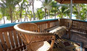 - une terrasse couverte avec 2 chaises en osier et un banc dans l'établissement Putuo eco-lodge, à Dadale 21 autres photos