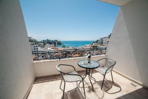 a balcony with a table and two chairs and the ocean at Hotel NOBEL Ulcinj in Ulcinj
