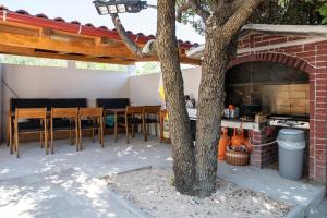 d'une terrasse avec une table, des chaises et un four à pizza. dans l'établissement VIlla Laki Rab, à Rab